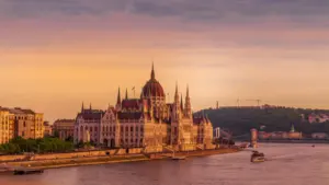 Węgierski Parlament w Budapeszcie nad Dunajem w promieniach wschodzącego słońca.