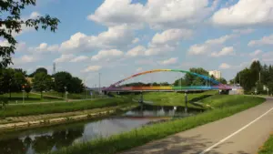 Kolorowy most nad rzeką w Rzeszowie przy ścieżce rowerowej w słoneczny dzień.